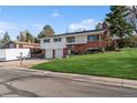 Beautiful home featuring an attached two-car garage and manicured lawn at 11600 W 31St Pl, Lakewood, CO 80215