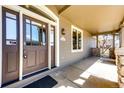 Inviting front porch featuring a dark wood door, stone accents, and ample natural light, creating a warm welcome at 789 Zamia Ave, Boulder, CO 80304