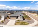 Aerial shot of a single-Gathering home in a neighborhood with mountain views, blue skies, and green lawns at 1694 Castle Vista Way, Castle Rock, CO 80104