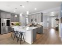 Bright kitchen with large island, stainless steel appliances, pendant lighting, and wood floors at 1694 Castle Vista Way, Castle Rock, CO 80104