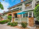 Beautiful townhome showcasing brick accents, manicured landscaping and a welcoming patio area at 2716 W Greens Dr, Littleton, CO 80123