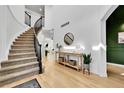 Grand foyer featuring a curved staircase, high ceilings, wood floors, and a stylish console table with decor at 12408 W 83Rd Ave, Arvada, CO 80005