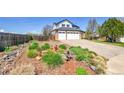 Artistic front yard with interesting plants, mulch, decorative rocks, rock border, and a view of the home's garage at 12408 W 83Rd Ave, Arvada, CO 80005