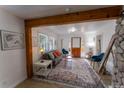 Inviting living room featuring rustic wood beam, stylish rug, and comfortable seating flooded with natural light at 34480 County Road 17, Elizabeth, CO 80107