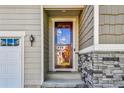 Inviting front entrance with a stylish glass door and stone accents, enhancing curb appeal at 27862 E 9Th Dr, Aurora, CO 80018