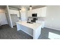 Bright kitchen features white cabinets, a center island with seating, and stainless steel appliances at 2303 Peregrine Dr, Brighton, CO 80601