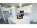 Modern kitchen featuring white cabinets, quartz countertops, and stainless steel appliances at 2303 Peregrine Dr, Brighton, CO 80601