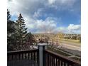 Enjoy a scenic view of trees, street and neighborhood from this cozy balcony with decorative wood railing at 2855 Rock Creek Cir # 129, Superior, CO 80027