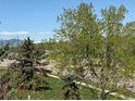 Scenic view of trees, lawn, and a road with mountains in the distance on a clear day at 2855 Rock Creek Cir # 129, Superior, CO 80027