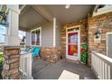 Front porch featuring stone accents, a red door and outdoor seating area at 5439 Innisbrook Loop, Elizabeth, CO 80107