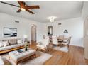 Open concept living room with hardwood floors, large windows, and arched doorways at 3050 S Delaware St, Englewood, CO 80110