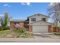 Charming two-story home featuring a brick facade, two-car garage and manicured front yard at 7140 S Reed Ct, Littleton, CO 80128