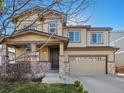 Inviting two-story home with stone accents, covered porch, and a spacious two-car garage with blue skies at 41 Garner Ln, Erie, CO 80516