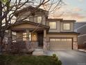 Beautiful two-story home featuring a two-car garage, stone accents, and a welcoming front porch at sunset at 41 Garner Ln, Erie, CO 80516