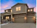 Beautiful two-story home with stone veneer and neutral siding, showcasing a welcoming front porch and an attached two-car garage at 887 Sundance Ln, Erie, CO 80516