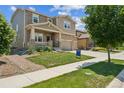 Attractive two-story home featuring stone accents, a welcoming front porch, and a well-cared-for lawn at 887 Sundance Ln, Erie, CO 80516