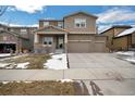 Attractive two-story home with a stone facade and complementary siding, featuring a spacious driveway and an inviting front porch at 887 Sundance Ln, Erie, CO 80516