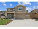 Beautiful two-story home with a stone and siding facade, a two-car garage, and a well-maintained lawn at 887 Sundance Ln, Erie, CO 80516