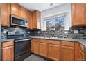 Well-equipped kitchen boasts updated appliances, granite countertops, and a stylish backsplash at 19046 E 57Th Pl # A, Denver, CO 80249
