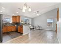Inviting living room with hardwood floors adjacent to a kitchen featuring ample natural light and modern decor at 19046 E 57Th Pl # A, Denver, CO 80249