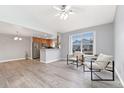 Bright living room featuring hardwood floors, modern chairs, and a view of the outdoors through a large window at 19046 E 57Th Pl # A, Denver, CO 80249