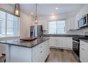 Bright kitchen featuring white cabinets, granite countertops, stainless steel appliances, and an island with a butcher block at 23670 E 41St Ave, Aurora, CO 80019