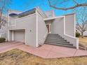 Two-story home featuring a covered balcony, attached garage, and elevated front entry with concrete stairs at 9200 E Cherry Creek South Dr # 29, Denver, CO 80231