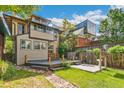 Expansive backyard featuring a wooden deck, patio area, lush lawn, and privacy fence, perfect for outdoor living at 1451 N Gilpin St, Denver, CO 80218