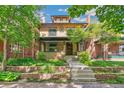 Charming brick home featuring a front yard with lush greenery and a welcoming entrance at 1451 N Gilpin St, Denver, CO 80218