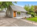 Gray single Gathering home with a detached garage, and manicured lawn and a charming porch at 2535 S Julian St, Denver, CO 80219