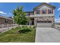 Beautiful two-story home with stone accents, red shutters, landscaped lawn and attached two car garage at 5789 Echo Park Cir, Castle Rock, CO 80104