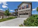 Two-story home features stone accents, red shutters, landscaped lawn, attached two car garage, and concrete driveway at 5789 Echo Park Cir, Castle Rock, CO 80104