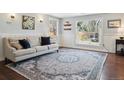 Bright living room featuring hardwood floors, a plush sofa, and large windows at 2733 S Riverview Dr, Idledale, CO 80453