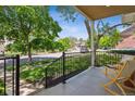 Inviting front porch with seating, featuring black railings and a view of the tree-lined street at 2844 Quitman St, Denver, CO 80212