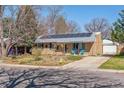 Charming brick home with a covered porch, blue accents, and a well-manicured lawn at 1744 S Leyden St, Denver, CO 80224