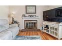 Living room with a brick fireplace, mantle with decorations, and large window at 1744 S Leyden St, Denver, CO 80224