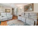 Comfortable living room featuring hardwood floors, neutral colors, and reclining sofas at 1744 S Leyden St, Denver, CO 80224