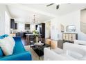 Open-concept living and dining area features a modern black table, sleek furniture, and plenty of natural light at 8953 E Northfield Blvd, Denver, CO 80238