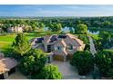 Stunning aerial view of a luxury home with solar panels overlooking a golf course and lake at 2421 Ranch Reserve Rdg, Denver, CO 80234