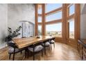 Bright dining room with floor-to-ceiling windows and a unique wooden table with seating for eight at 2421 Ranch Reserve Rdg, Denver, CO 80234