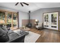 Cozy living room featuring hardwood floors, a wood burning stove, and large windows with natural light at 32252 Steven Way, Conifer, CO 80433