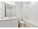 Modern bathroom with white cabinets, and a shower-tub combo with white tile at 9712 Cathay St, Commerce City, CO 80022
