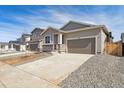 Attractive home featuring stone accents and a large concrete driveway at 9712 Cathay St, Commerce City, CO 80022