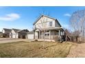 Inviting two-story home with a covered porch, set on a landscaped lot with mature trees at 2331 Ance St, Strasburg, CO 80136
