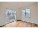 Bright bedroom featuring wood floors and a sliding glass door leading to a balcony at 6847 S Webster St # A, Littleton, CO 80128