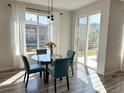 Bright breakfast nook with glass table, four chairs, and sliding glass door at 9482 Kendrick Way, Arvada, CO 80007