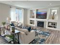 Bright living room featuring a fireplace, large window, and modern decor with an open floor plan at 9482 Kendrick Way, Arvada, CO 80007