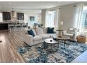 A stylish living room with modern furniture that is adjacent to a kitchen and dining area at 9482 Kendrick Way, Arvada, CO 80007