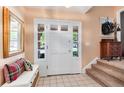 Bright entryway with a tiled floor, a white front door with sidelights, and a staircase leading to the upper level at 6624 S Sycamore St, Littleton, CO 80120