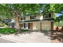 Side view of a well-maintained two-story home with a spacious driveway and an attached two-car garage at 6624 S Sycamore St, Littleton, CO 80120